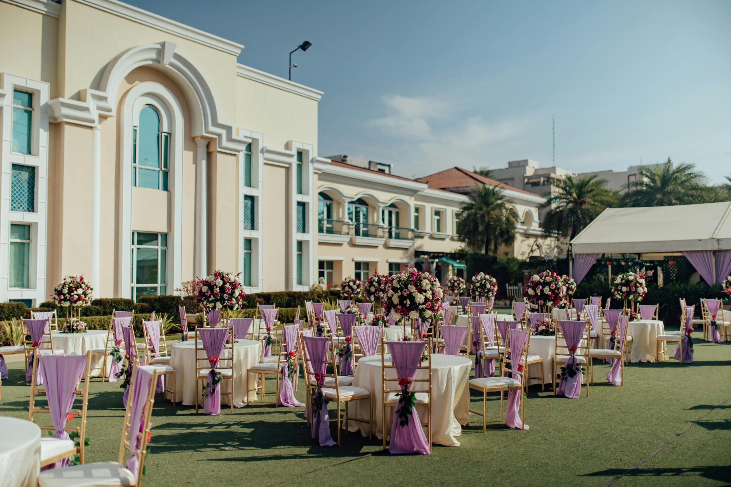 Luxurious outdoor wedding reception with floral arrangements and elegant decor.